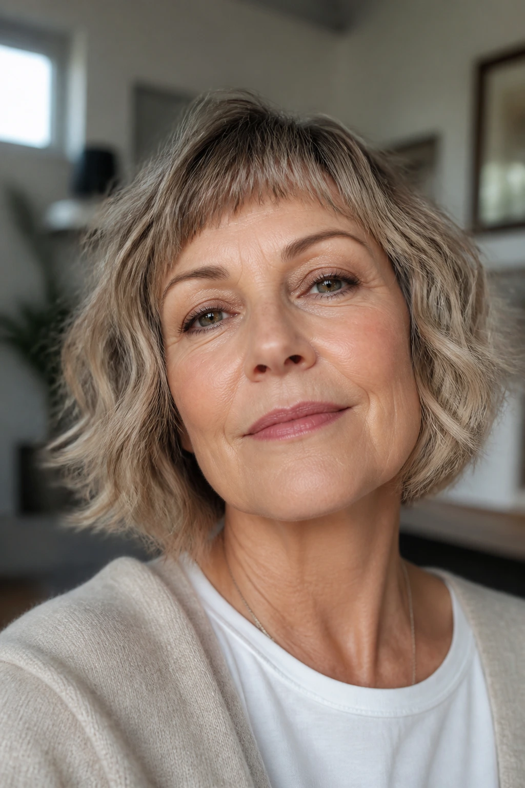 Close-up portrait of a real woman with a textured bob and feathered micro-bangs.