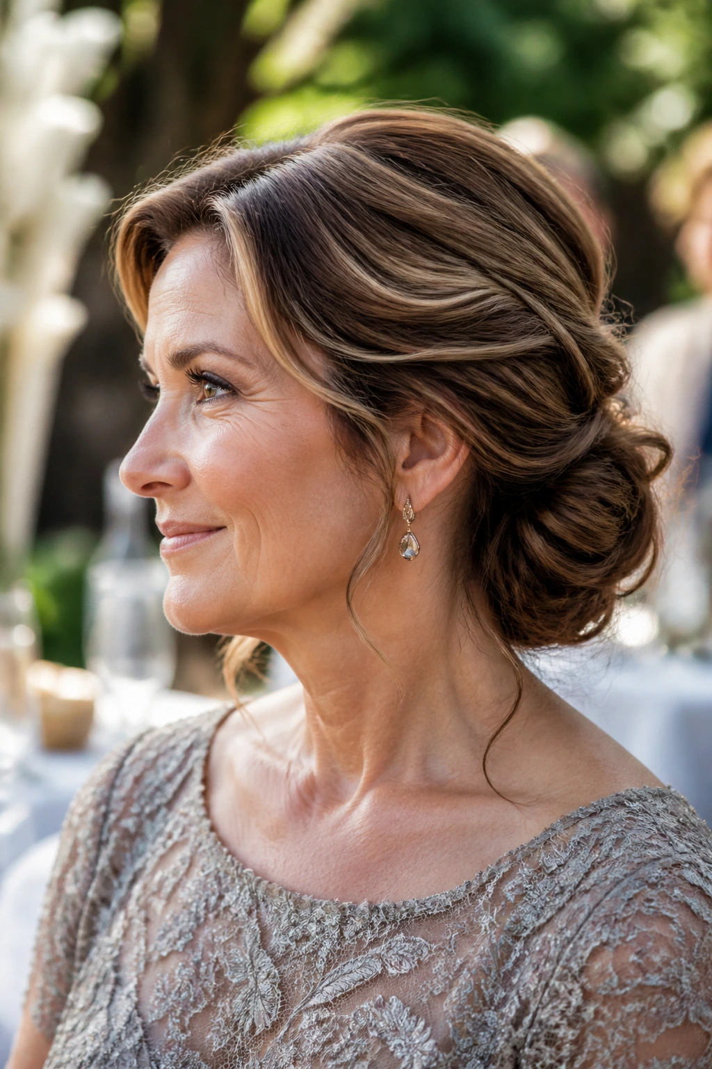 Close-up of a woman with a textured low bun and soft ends in garden light