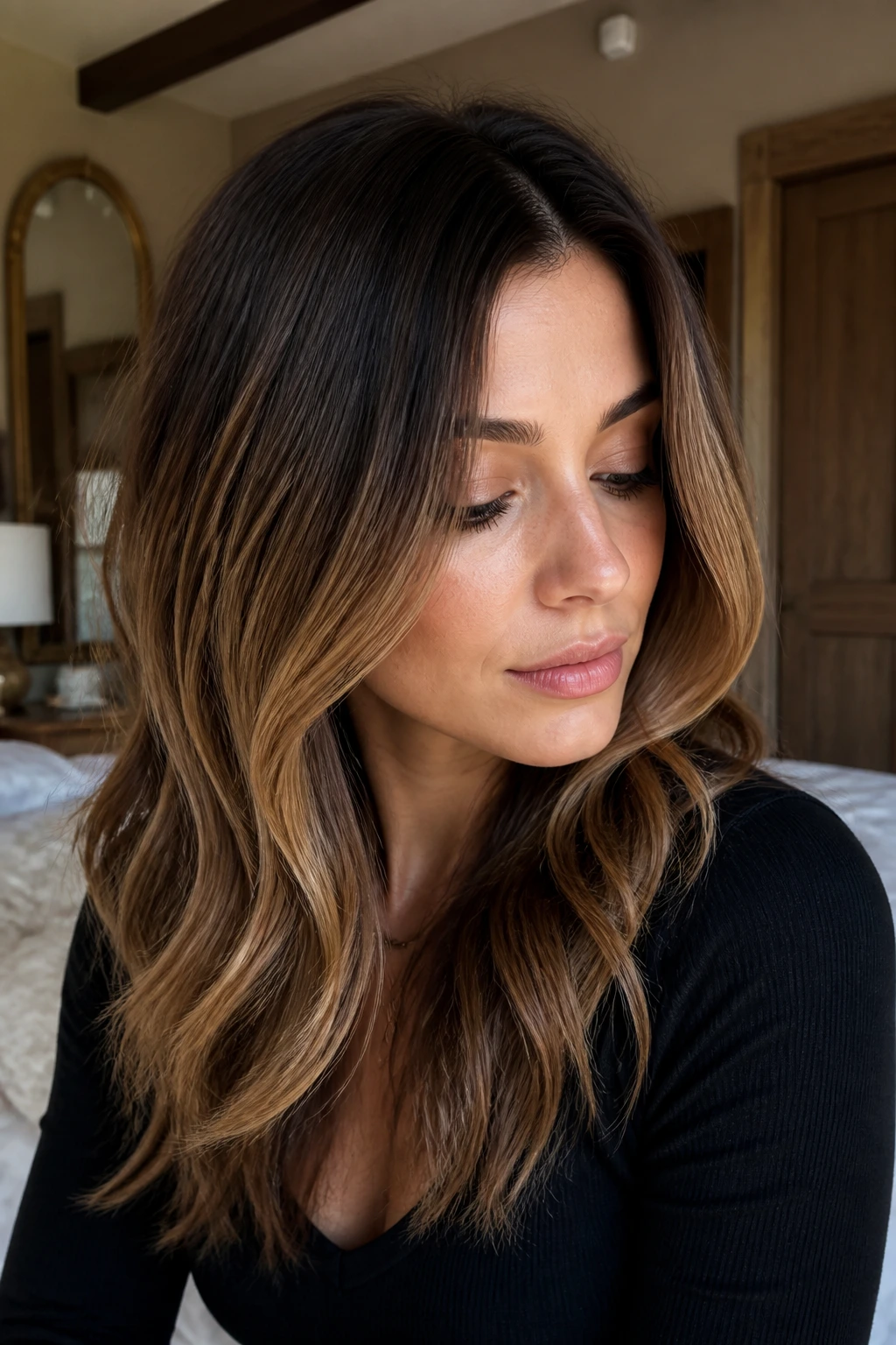 Close-up of a real woman showing Toffee Root Melt coloring on layered brunette hair.