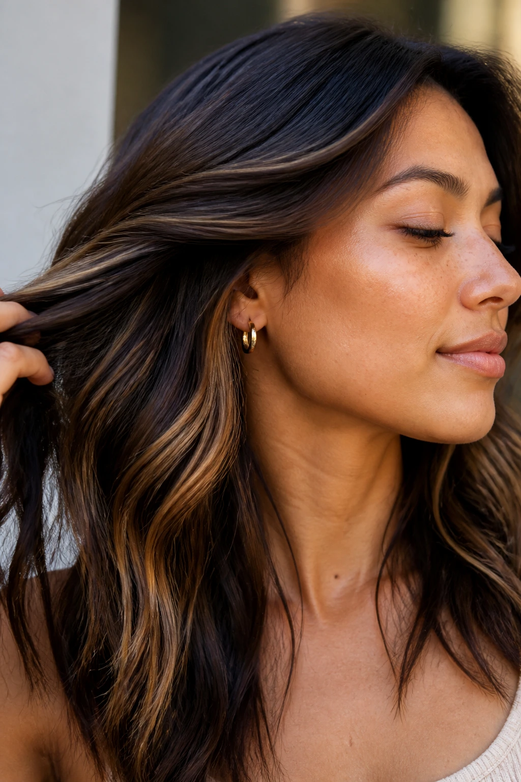 Close-up of real hair showing toffee underlights beneath the top layer