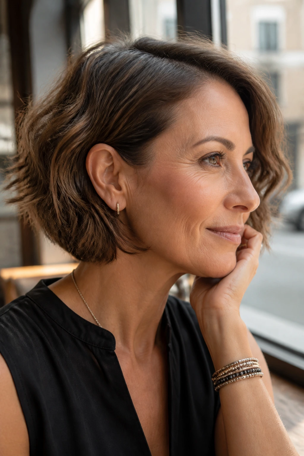 Real woman with tucked-behind-the-ear angled bob highlighting the cheekbone