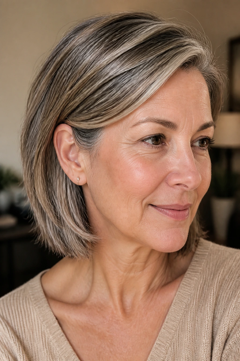 Close-up portrait of a woman with a tucked-behind-ear bob and silver-blend babylights