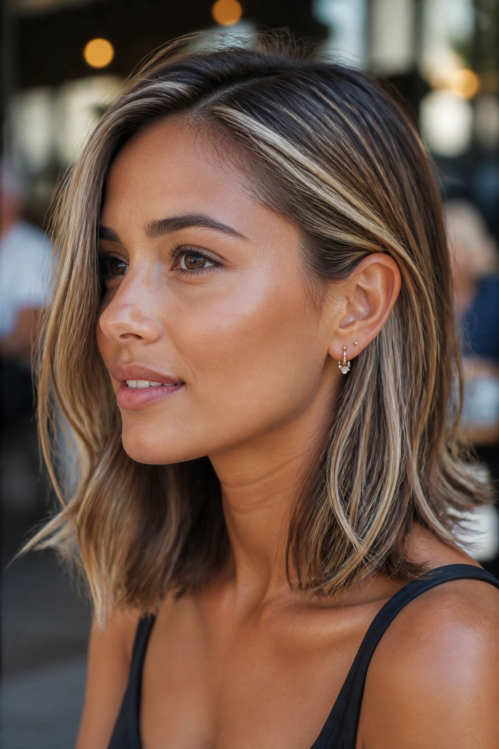 Close-up of a real woman with tucked-behind-ear cut and ribbon highlights.