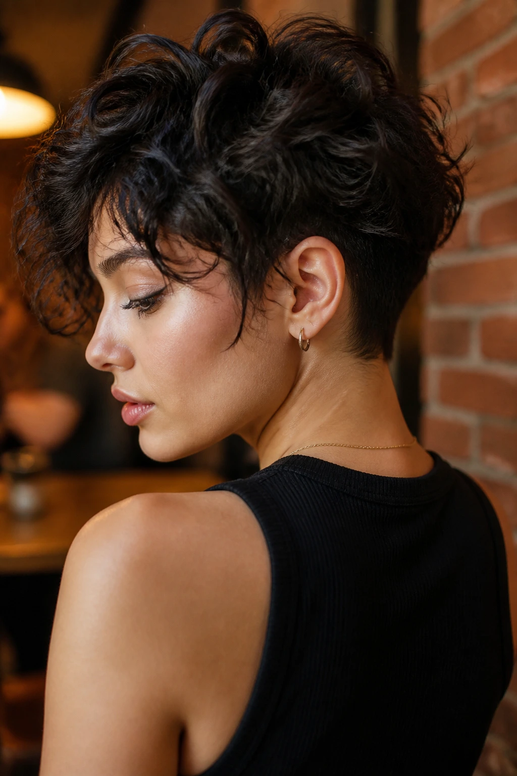 Close-up of a real woman with layered crop and hidden undercut at the nape, showing subtle contrast between layers and shaved area.