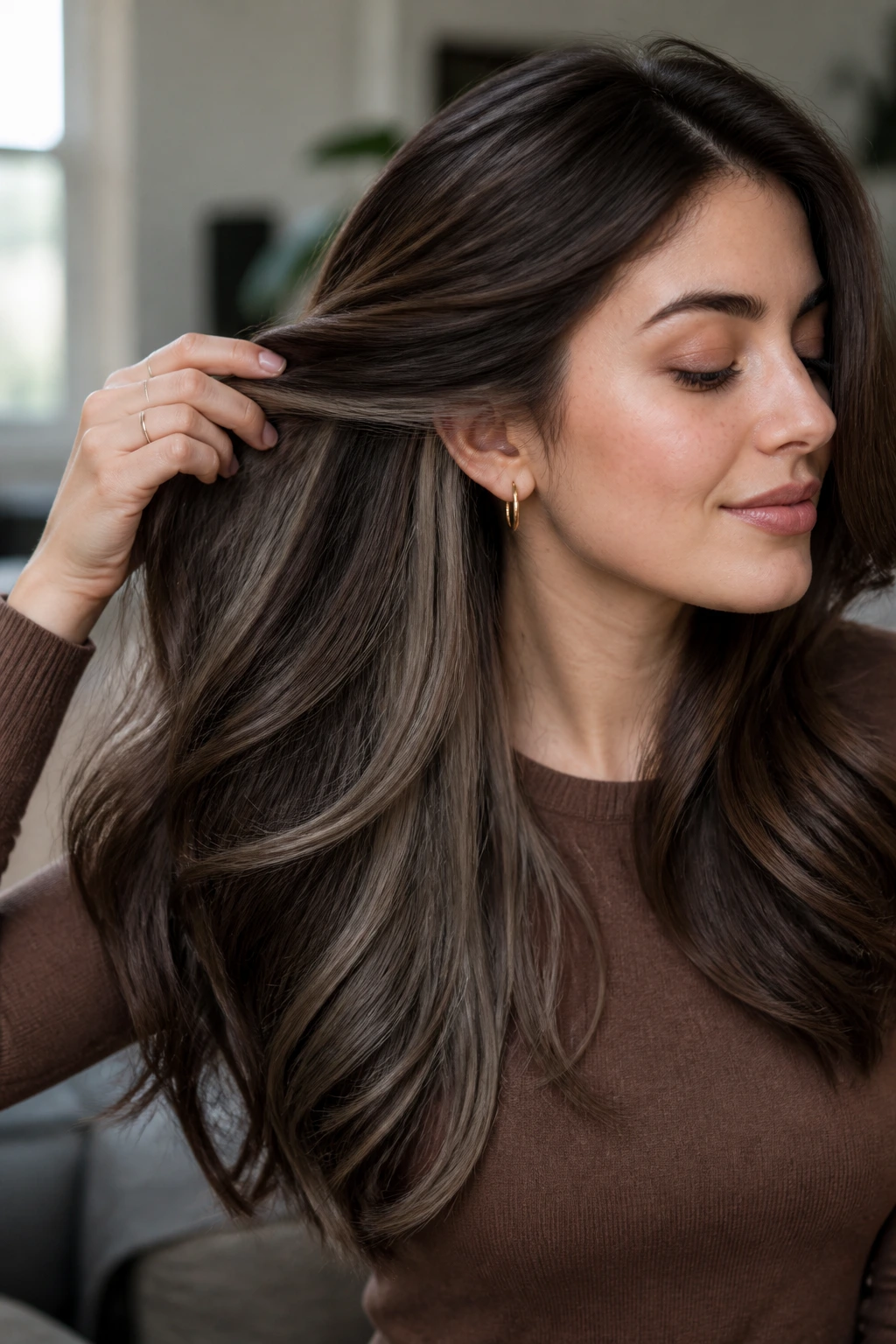 Close-up of a real woman with long hair showing hidden ash-brown underlayers peeking through.
