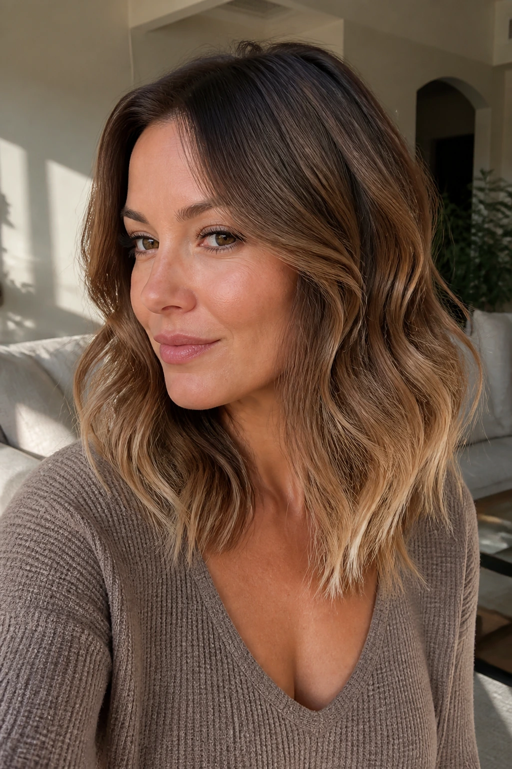Close-up of a real woman with warm mocha waves and painted ends