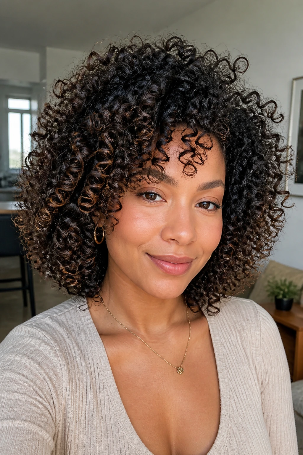 Portrait of a real woman with defined curls and lifted roots in a wash-and-go style