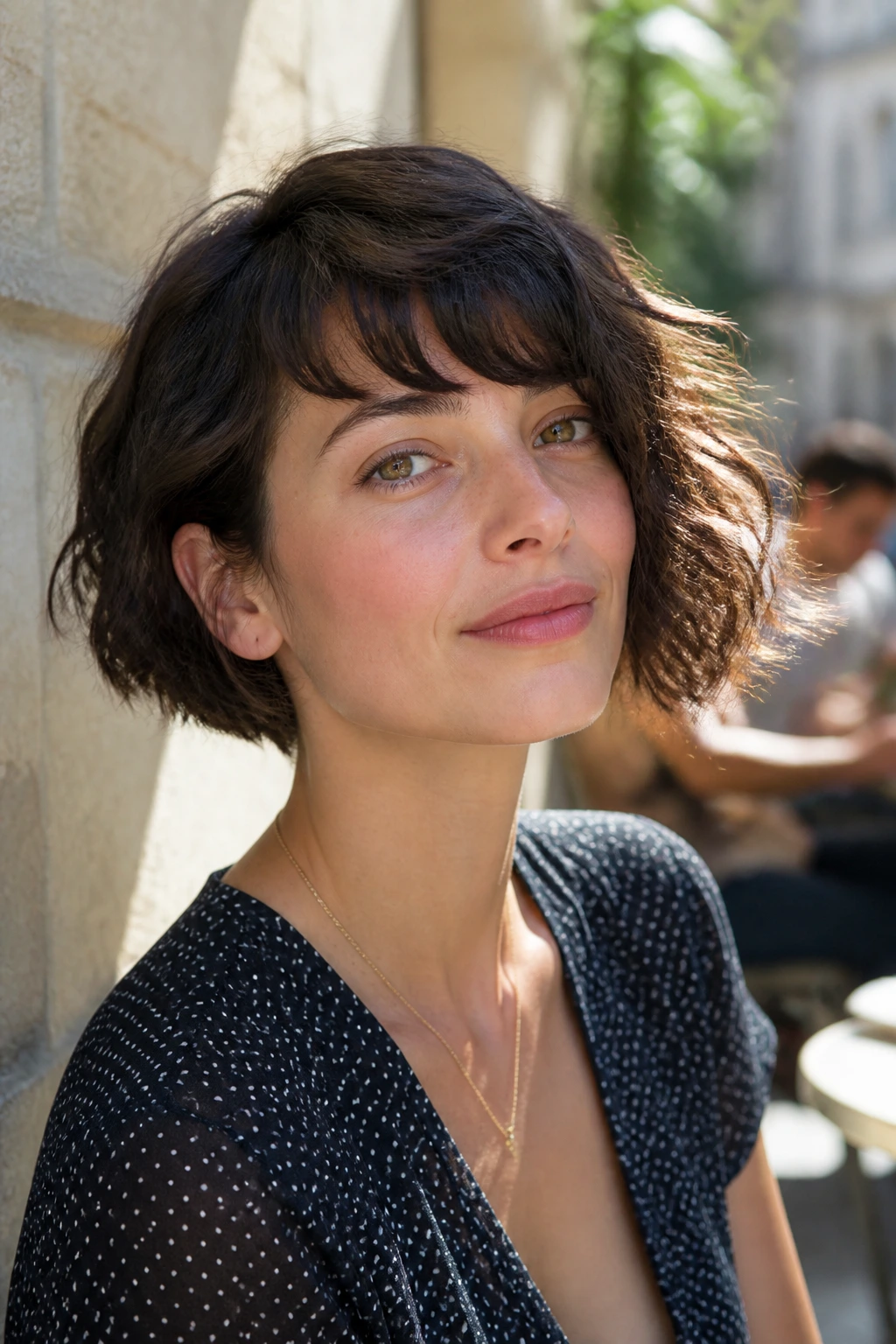 Real woman with wavy French bob and longer side in sunny outdoor setting