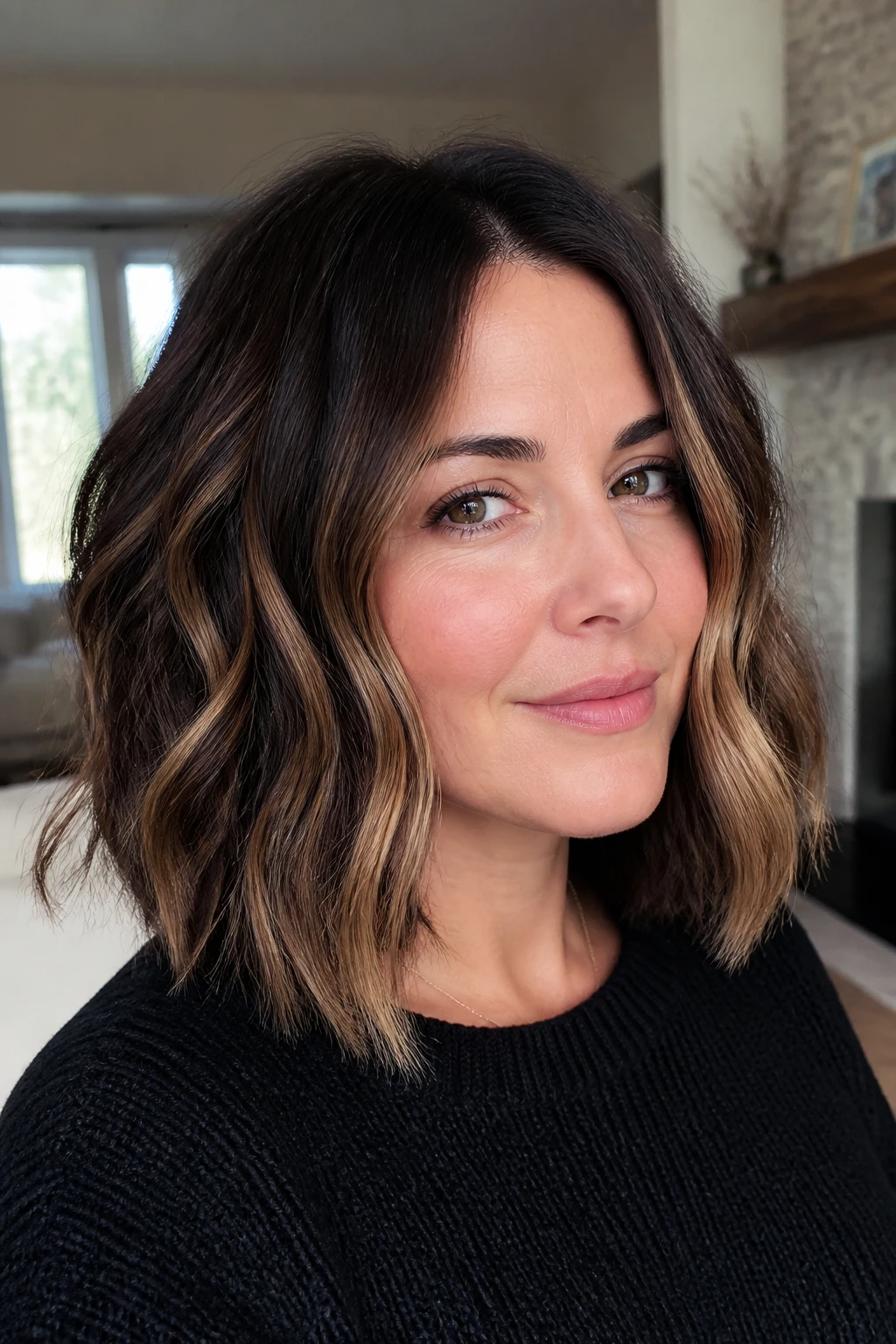 Close-up of a real woman with a shoulder-length wavy lob and scattered camel highlights.