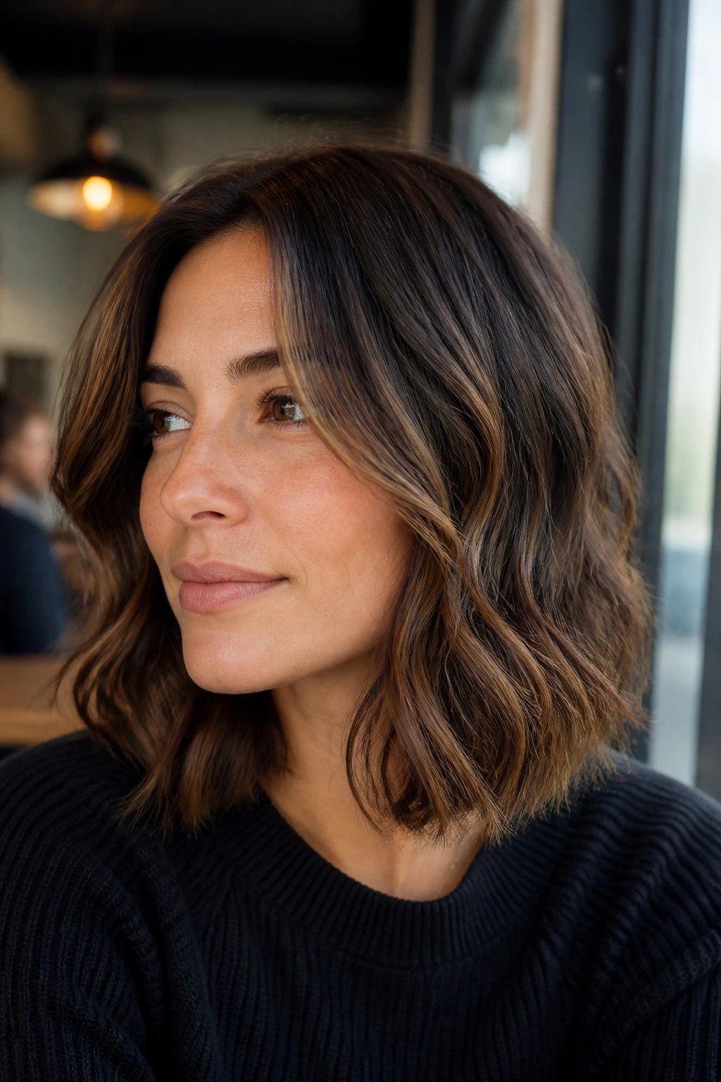 Close-up of a woman with a wavy lob and soft face-framing slices