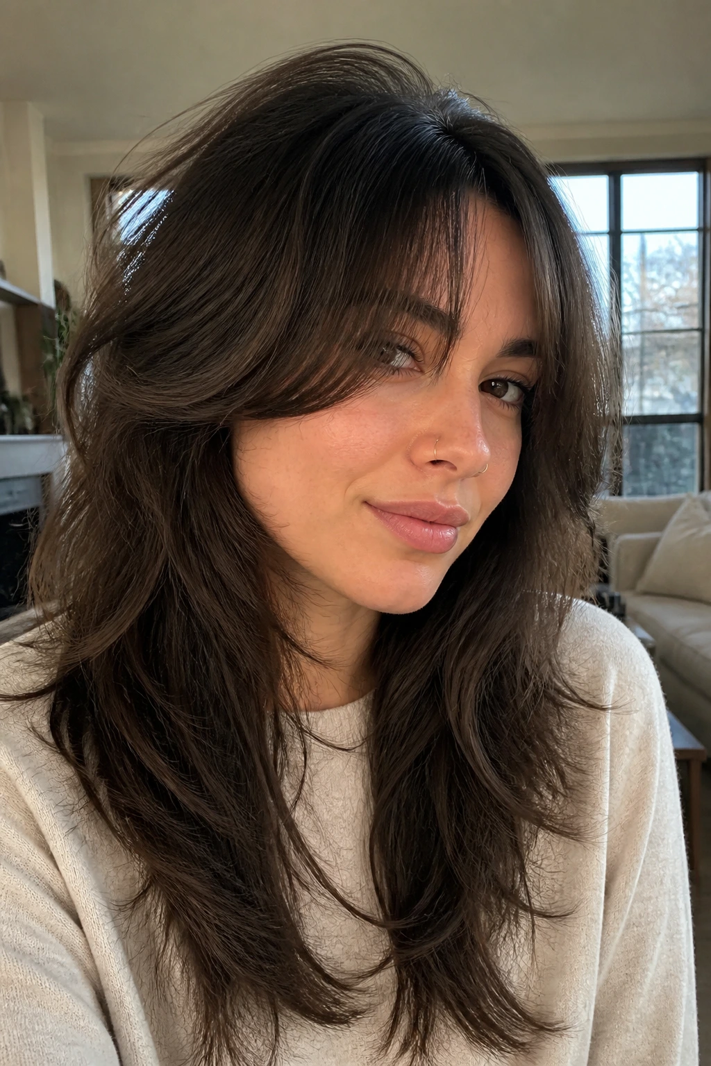 Close-up portrait of a real woman with a soft wolf cut and deep brunette lowlights