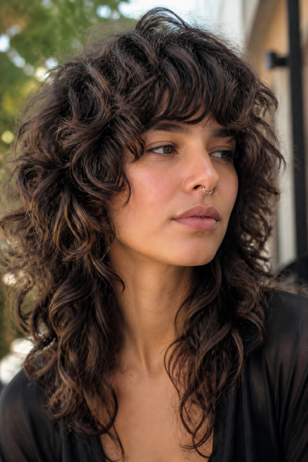 Real person with curly wolf cut and smoky brunette shadows at crown and nape
