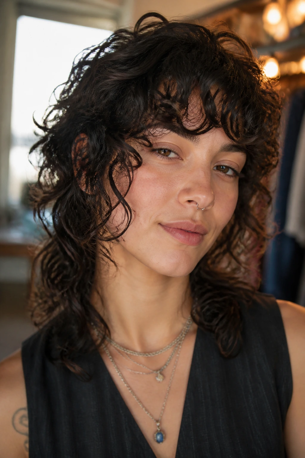 Close-up of a real person with a wolf cut and face-framing spirals.